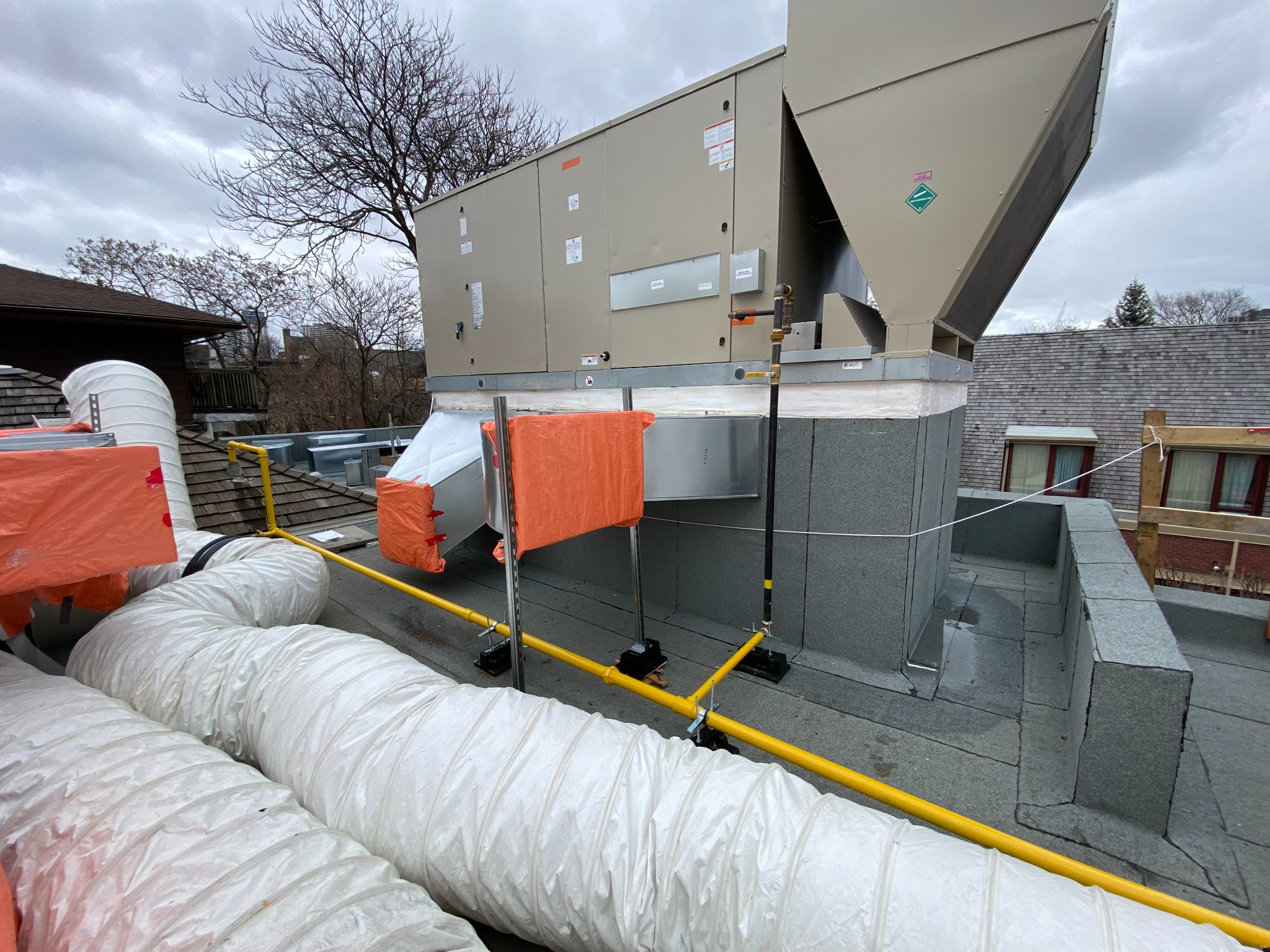 Rooftop HVAC unit with new supply and return duct connections on a commercial roof
